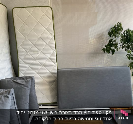 מזרנים וכריות אפורות מונחים על ספסל לבן